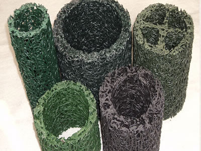 Five circular plastic blind drains in different shapes, colors and sizes are standing on the ground.