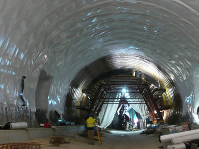 White ECB geomembrane wraps the whole arch of the tunnel, and there are some workers working.